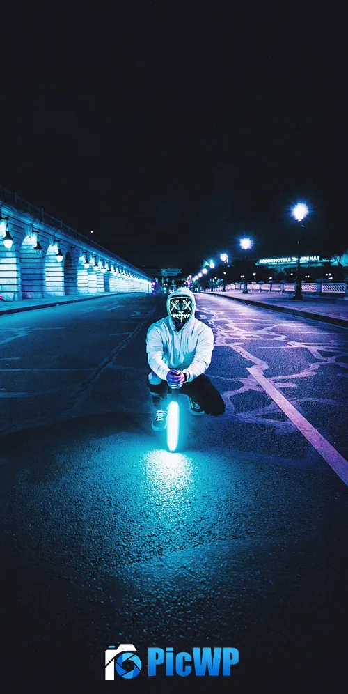 Man kneeling on a street holding a neon light 3K Mobile Wallpaper
