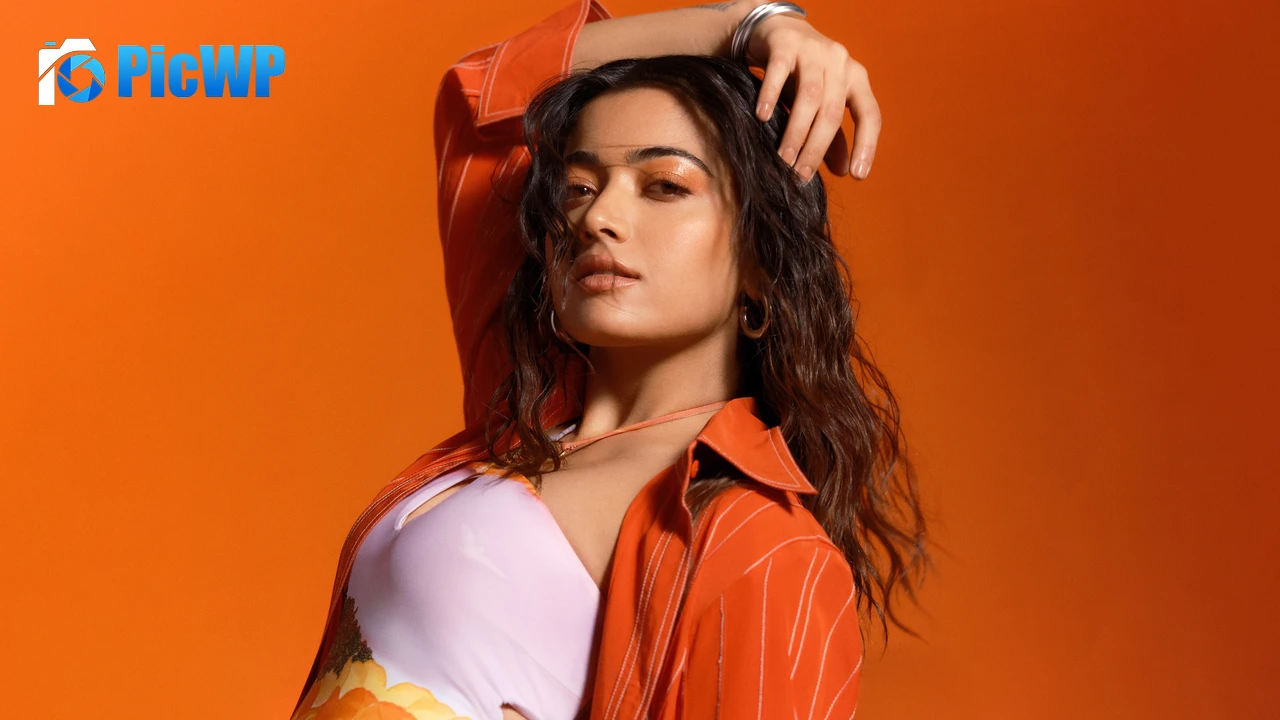 Rashmika Mandanna Orange background 8K PC Wallpaper